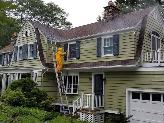 Man cleaning the house from exterior