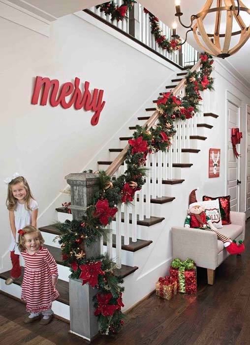 2 small girls standing near the decorated staircase