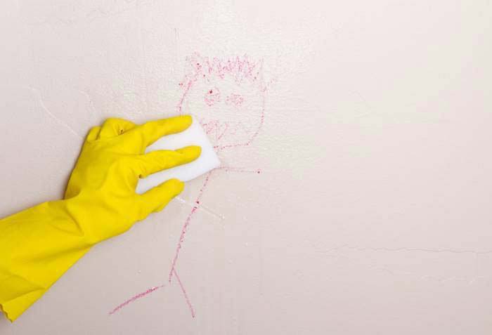 Man wiping a picture drawn on a wall