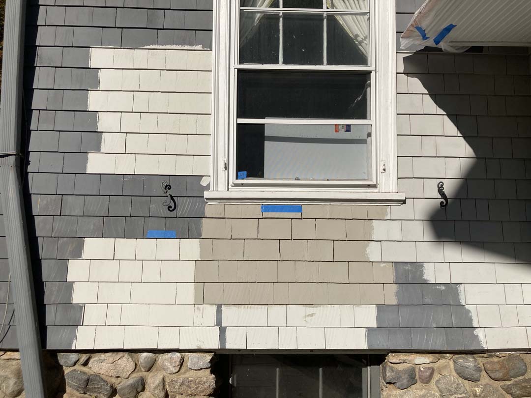 testing paint swatches on a home exterior